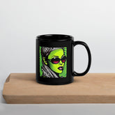 Close-up of black glossy mug with inked design.