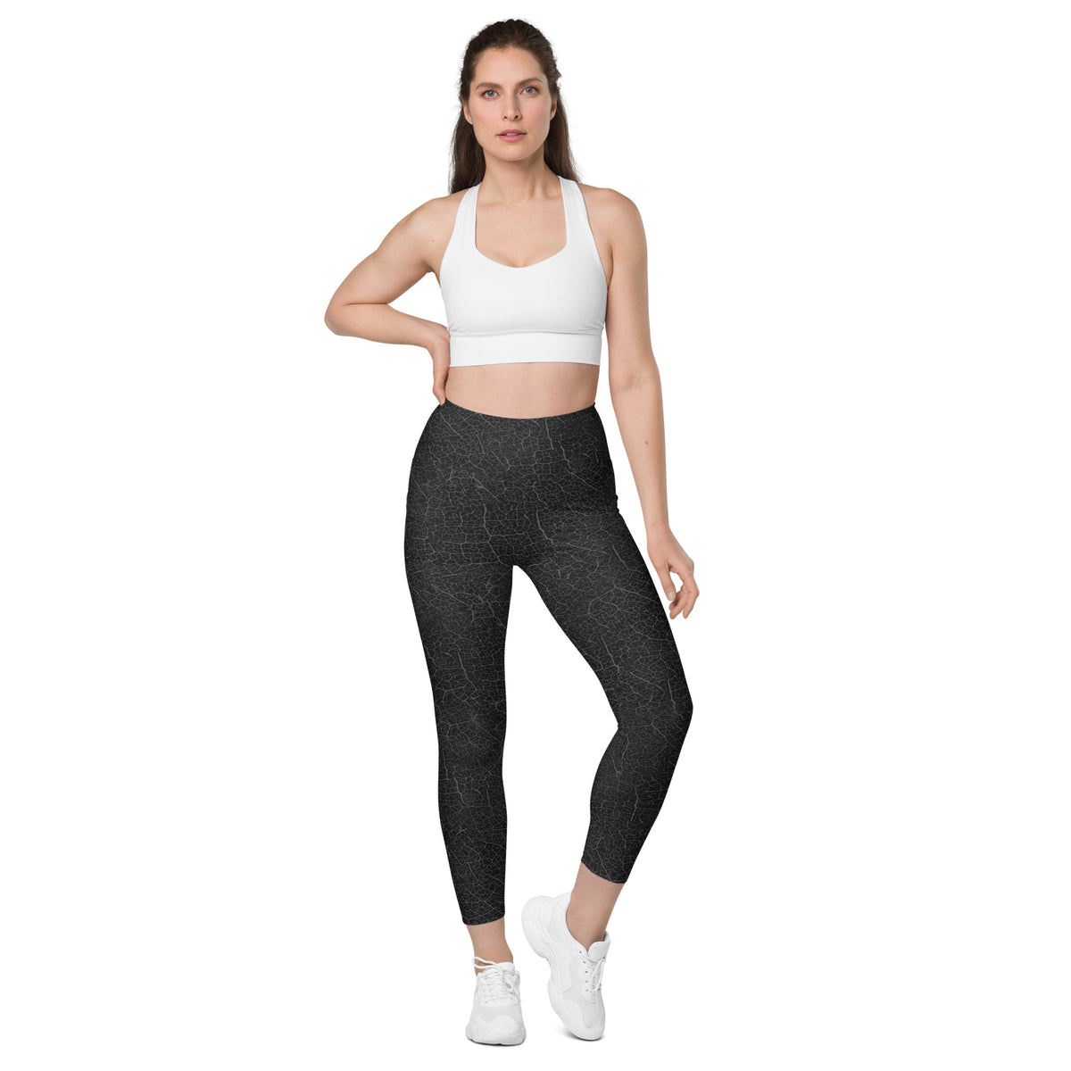 Woman in Botanical Bliss leggings, showcasing leaf texture and practical pockets for the nature lover.
