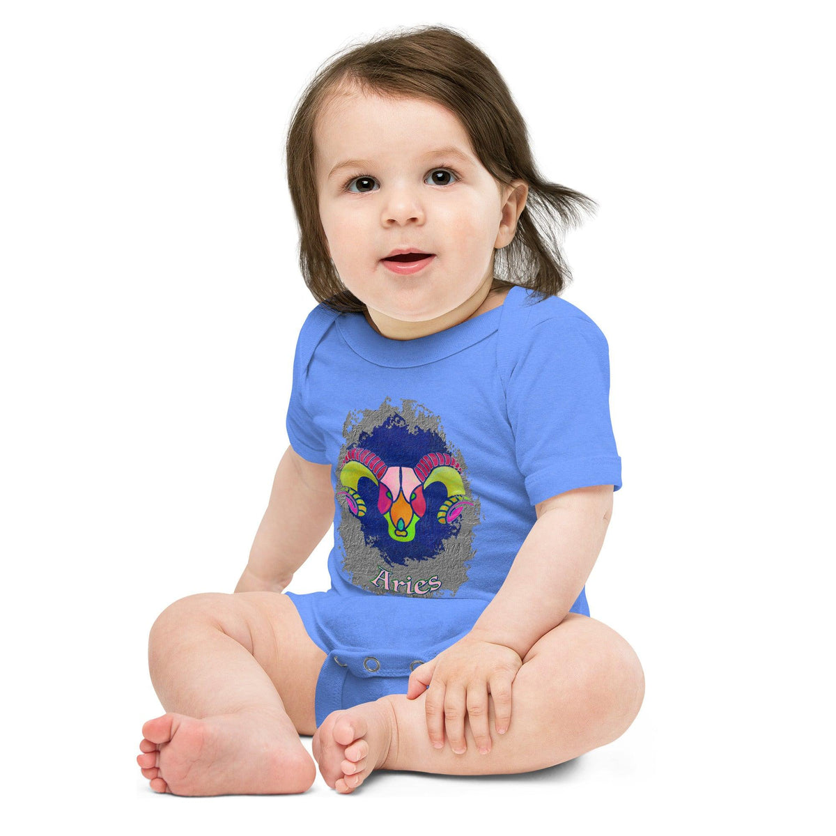 Infant wearing Aries short sleeve one-piece, smiling happily.