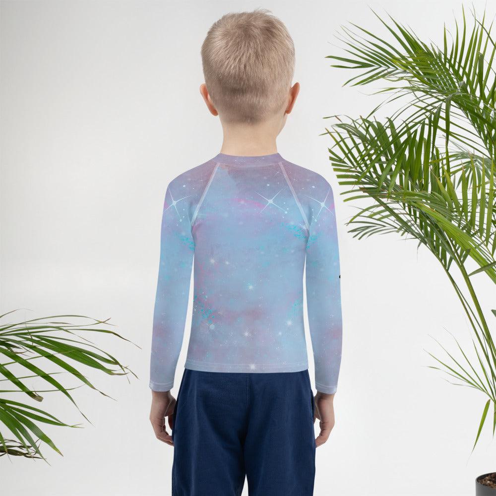 Side view of child in Fantasy Rash Guard looking at the sea.