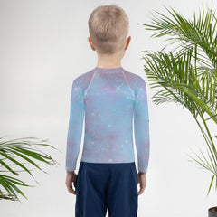 Side view of child in Fantasy Rash Guard looking at the sea.