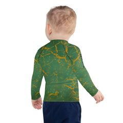 Child in Dreamy Giraffe Rash Guard enjoying the sunset on the beach.