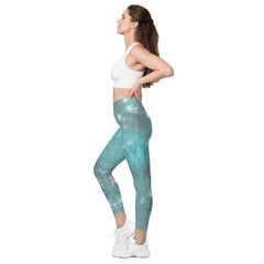 Person stretching in Enchanted Crossover Leggings with smartphone in pocket.
