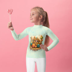 Child wearing Magical Confectionary Rash Guard with colorful candy patterns.