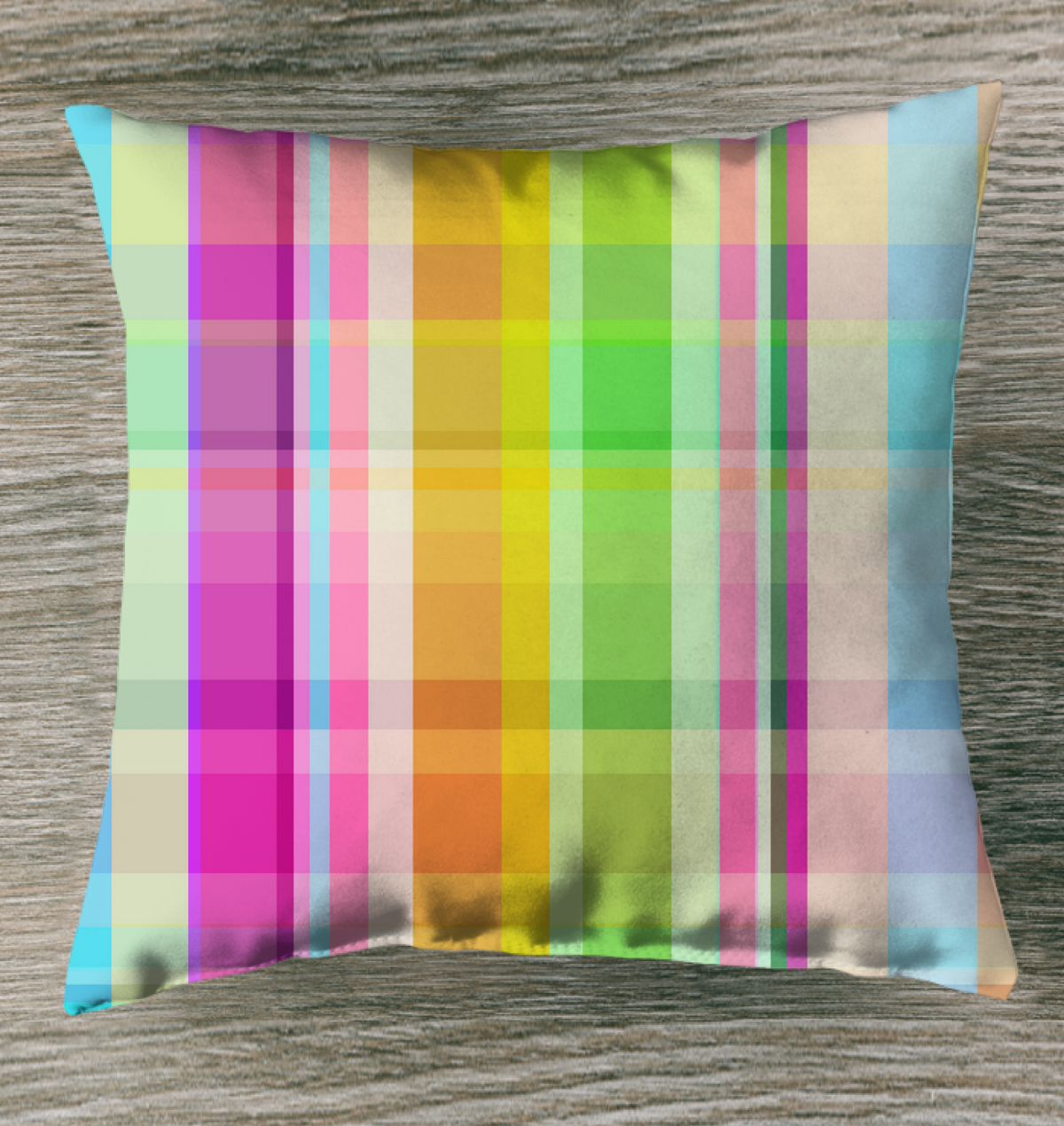 Electric Sunrise Outdoor Pillow displayed on a patio chair, featuring a vibrant sunrise-inspired design with shades of orange, yellow, and pink.