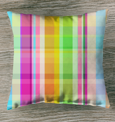 Electric Sunrise Outdoor Pillow displayed on a patio chair, featuring a vibrant sunrise-inspired design with shades of orange, yellow, and pink.