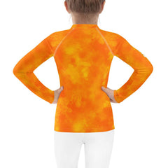 Child wearing Mystic Charm in Eyes rash guard at the beach.