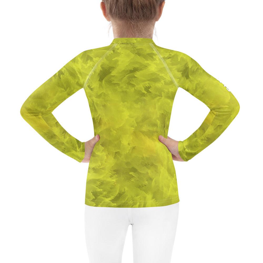 Back view of child in Regal Iris Parade rash guard by the sea.