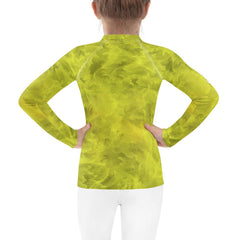 Back view of child in Regal Iris Parade rash guard by the sea.
