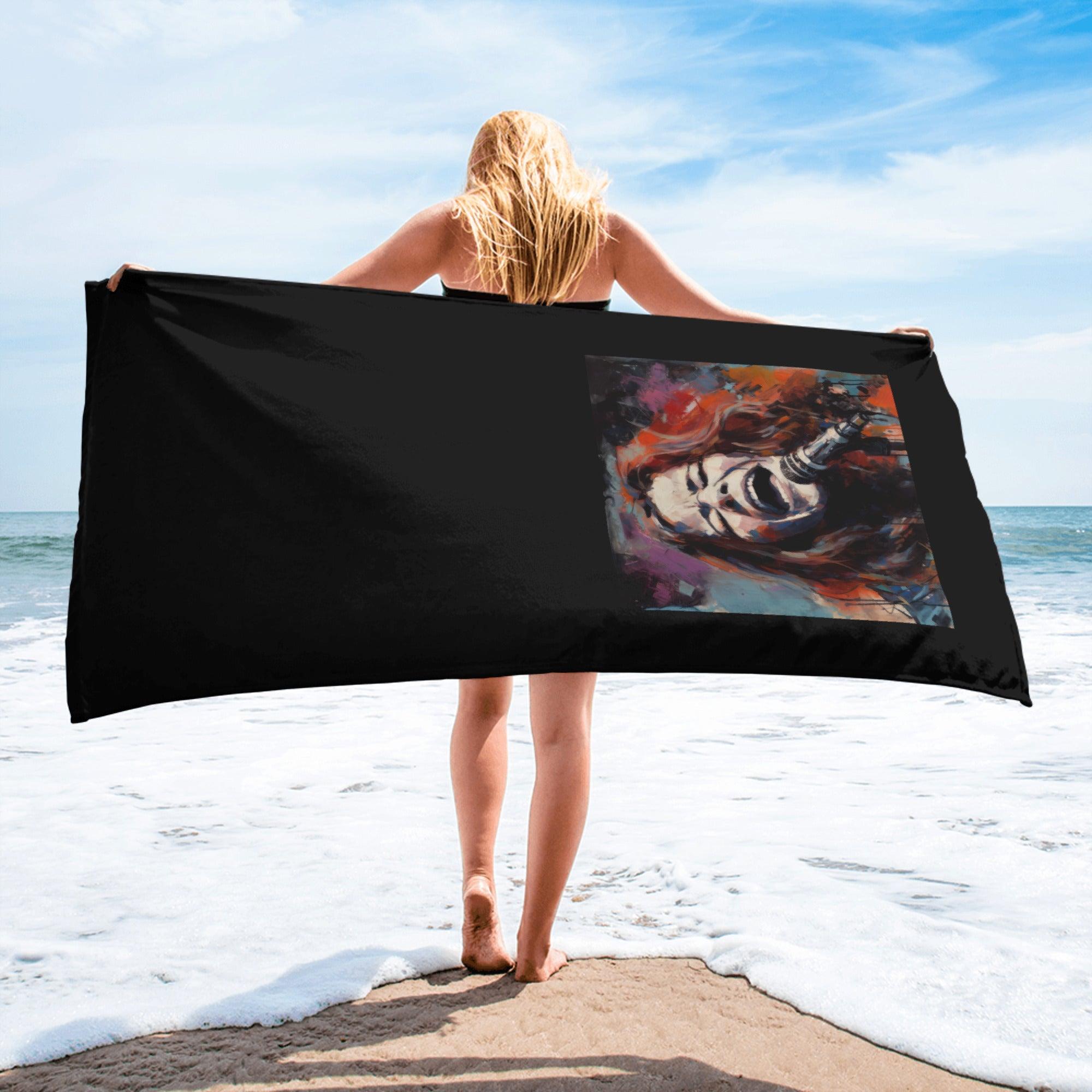 Brightly colored vibrant visions beach towel laid out on sandy beach.