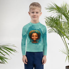 Child wearing Wondrous Childlike Gaze Kids Rash Guard playing at the beach.